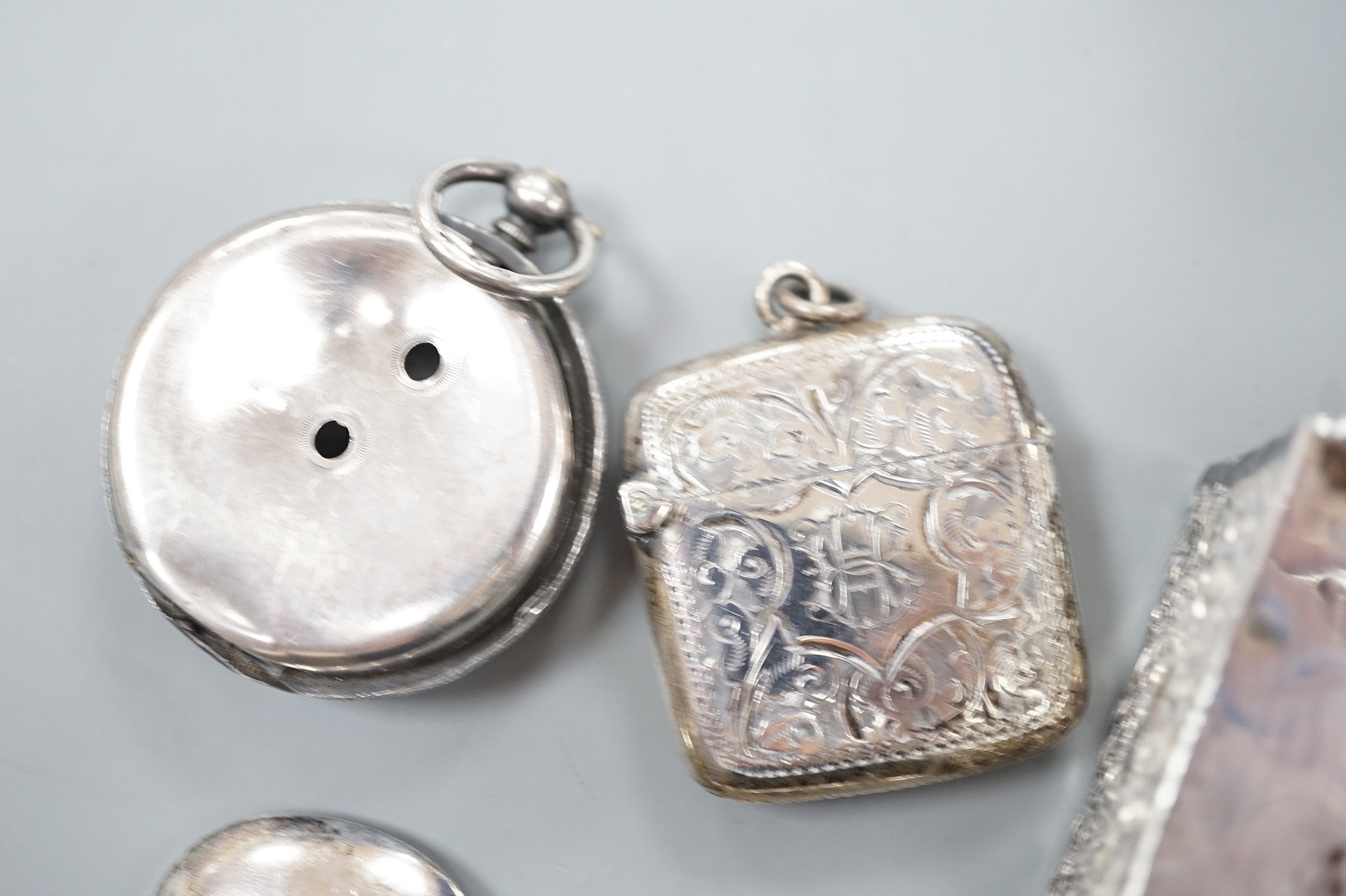 A late Victorian novelty white metal propelling pencil, modelled as a tennis racket, by Sampson Mordan & Co, 64mm, together with a watch case, silver vesta case, spoon and silver matchbox sleeve.